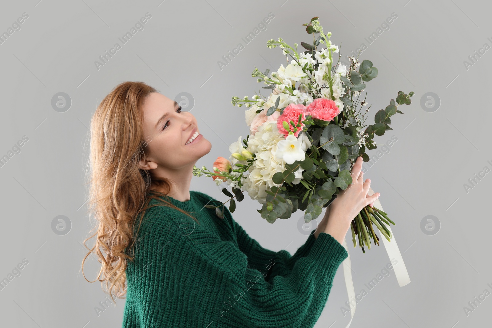 Photo of Beautiful woman with bouquet of flowers on grey background