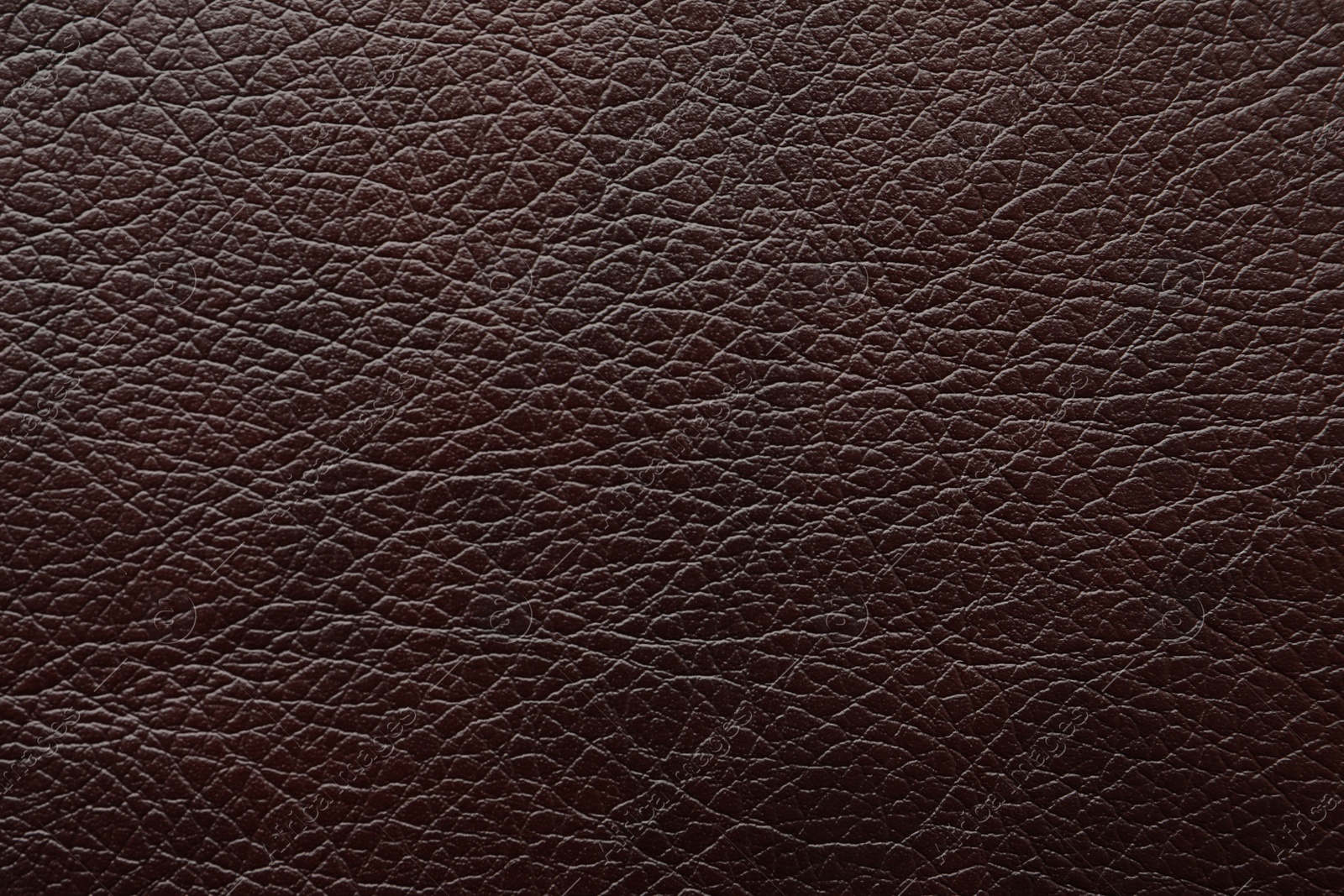 Photo of Texture of dark brown leather as background, closeup