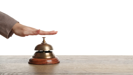 Photo of Woman ringing hotel service bell at wooden table