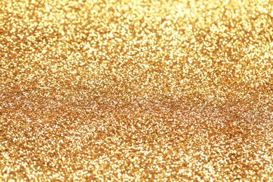 Beautiful golden shiny glitter as background, closeup