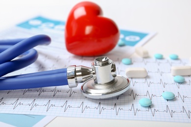 Photo of Stethoscope, cardiogram and pills on table. Cardiology service
