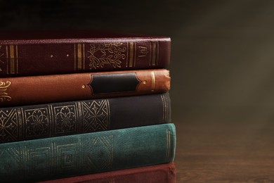 Image of Stack of old hardcover books on wooden table, closeup. Space for text