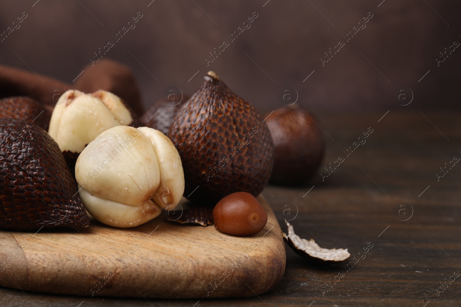 Photo of Fresh ripe salak fruits on wooden table, closeup. Space for text