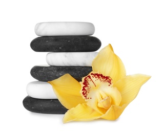 Photo of Stack of spa stones and beautiful orchid on white background