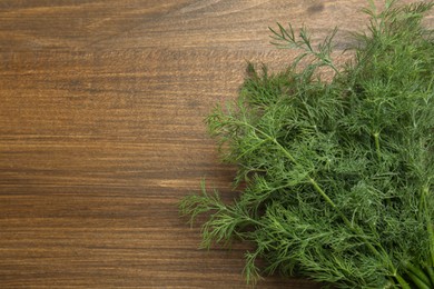 Fresh green dill on wooden table, top view. Space for text