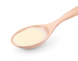 Photo of Wooden spoon with condensed milk isolated on white