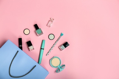 Flat lay composition with shopping bag and cosmetics on color background