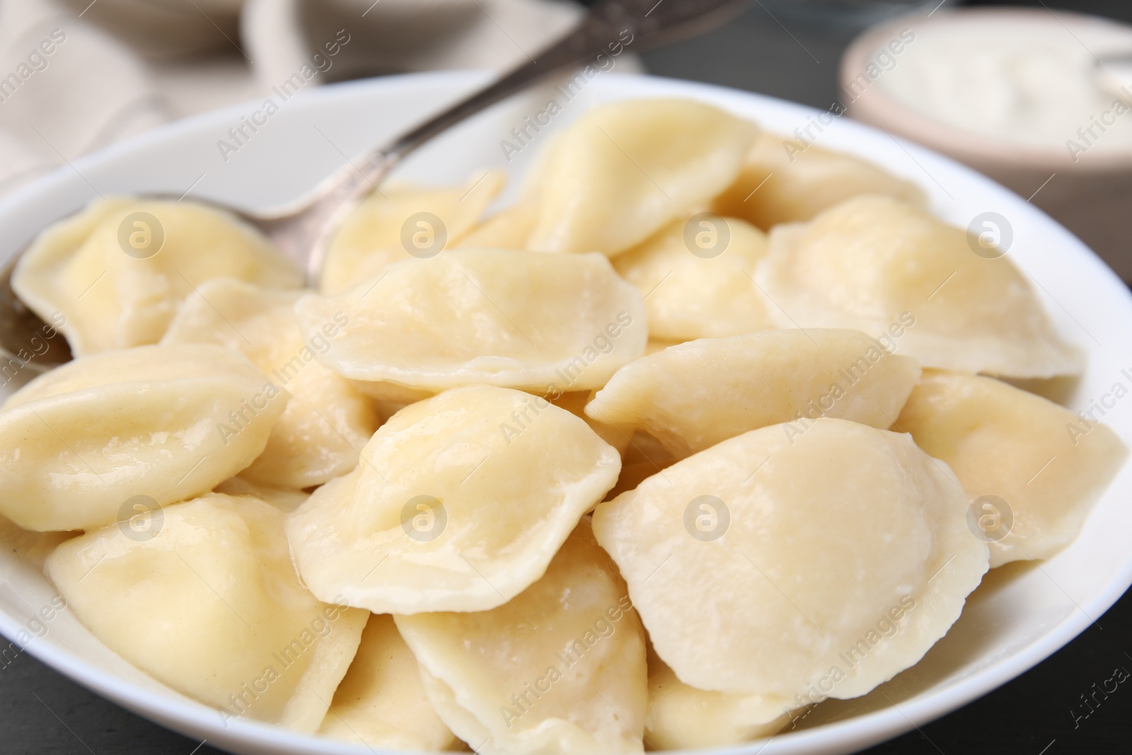 Photo of Plate of delicious dumplings (varenyky) with cottage cheese, closeup