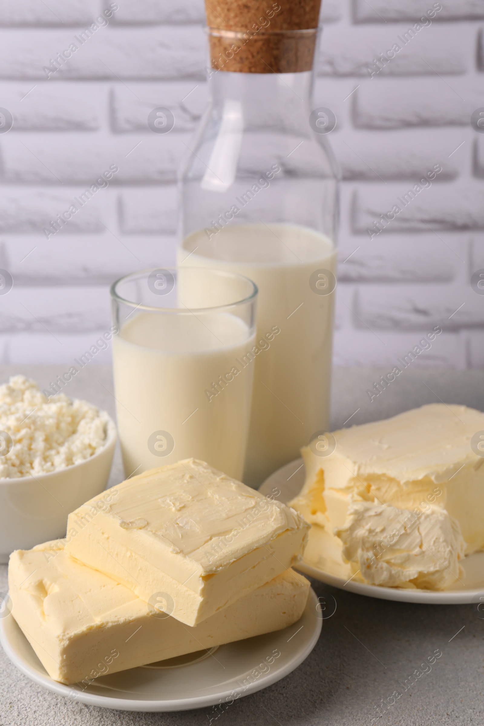 Photo of Tasty homemade butter and dairy products on white textured table