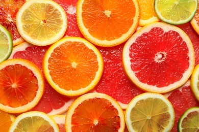 Slices of fresh citrus fruits as background, top view