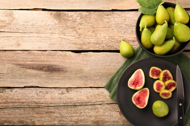 Cut and whole green figs with knife on wooden table, flat lay. Space for text