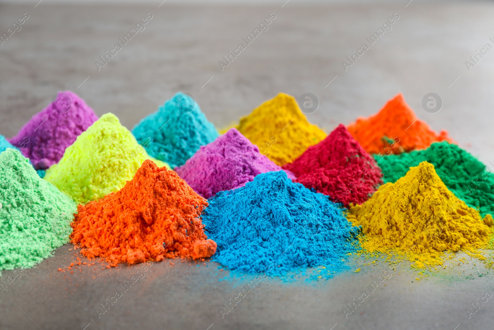 Photo of Colorful powder dyes on grey background. Holi festival