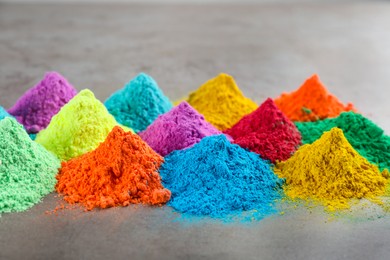 Photo of Colorful powder dyes on grey background. Holi festival
