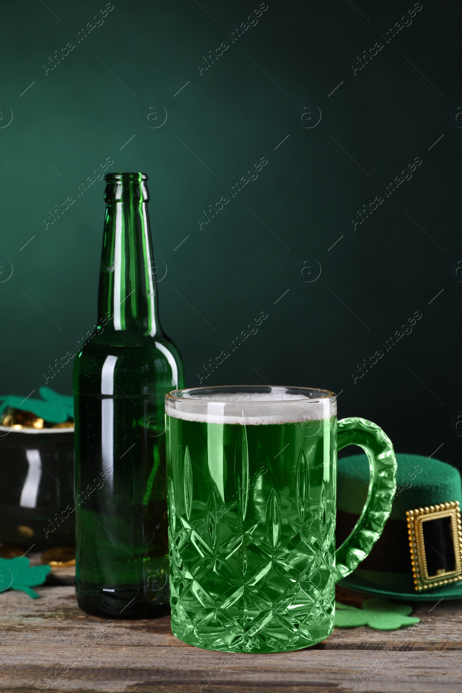 Photo of St. Patrick's day party. Green beer, leprechaun hat, pot of gold and decorative clover leaves on wooden table