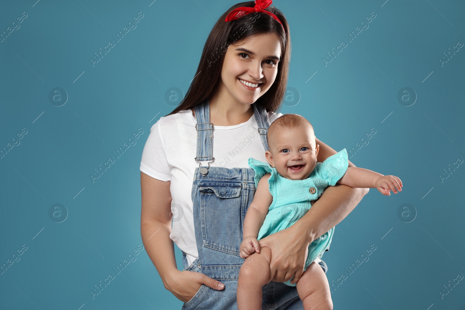 Photo of Beautiful mother with her cute baby on blue background