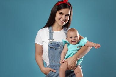 Beautiful mother with her cute baby on blue background