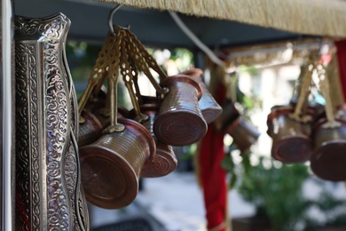 Closeup view of souvenir stall outdoors, focus on copper coffee pots