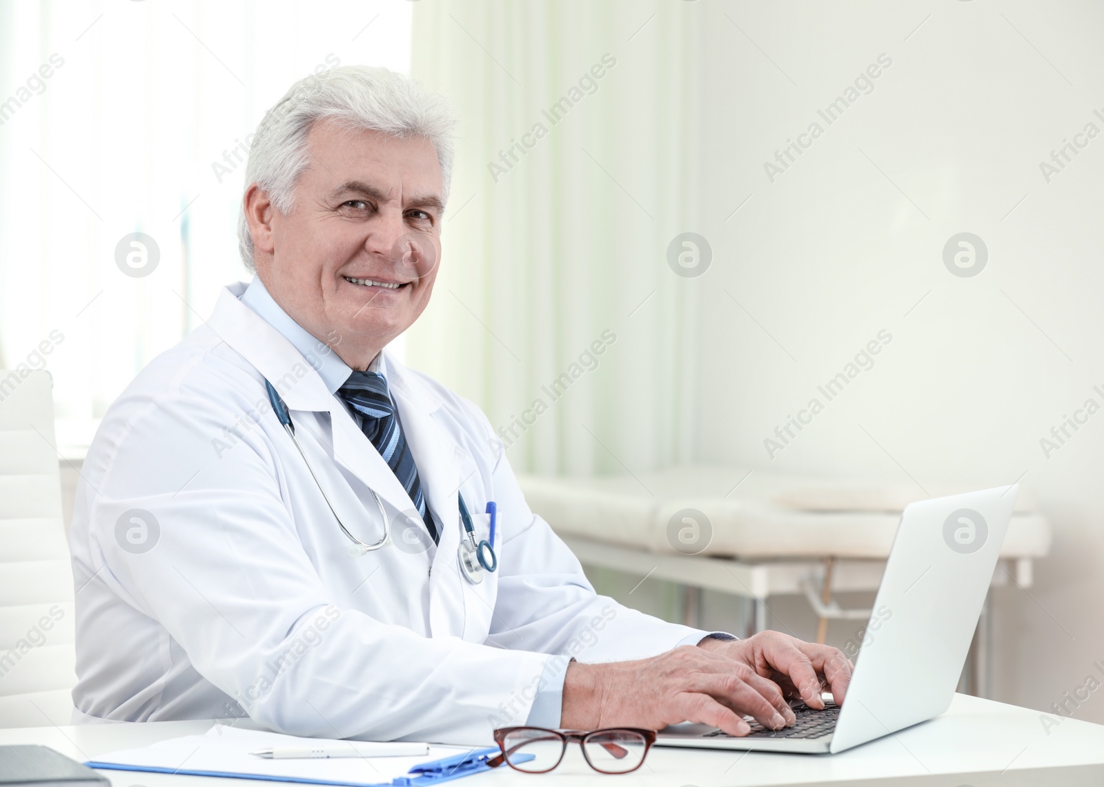 Photo of Portrait of senior doctor in white coat at workplace