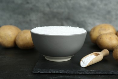 Photo of Starch and fresh potatoes on black table