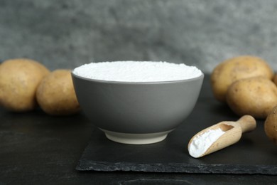 Starch and fresh potatoes on black table