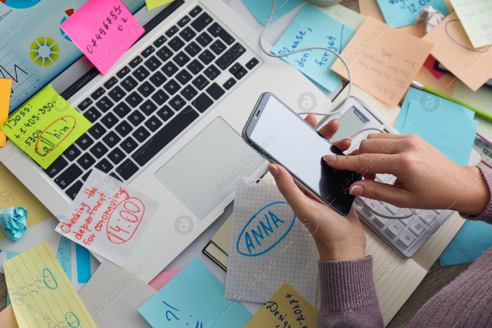 Photo of Overwhelmed woman working at messy office desk, above view