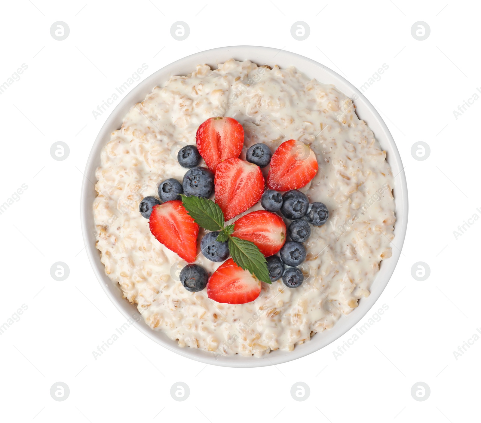 Photo of Tasty boiled oatmeal with berries in bowl isolated on white, top view