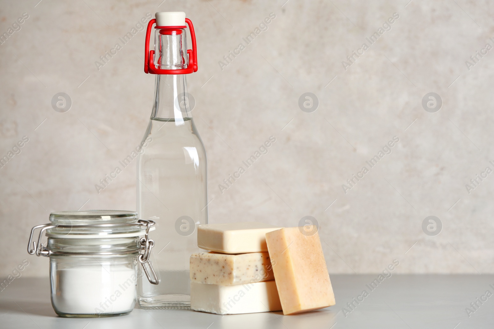 Photo of Composition with vinegar, baking soda and soap bars for cleaning on table. Space for text