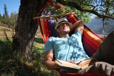 Man resting in hammock outdoors on sunny day