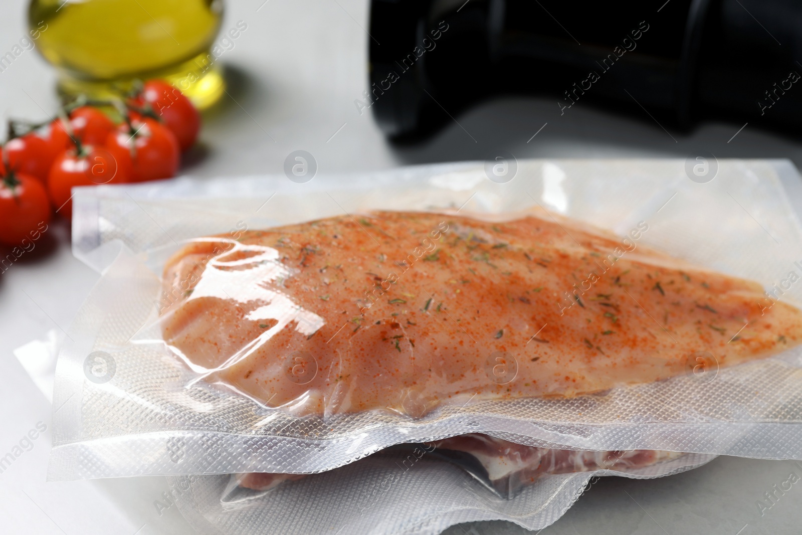 Photo of Vacuum packing with meat on white table, closeup. Sous vide cooking