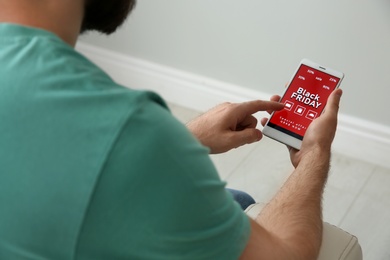 Photo of Man shopping online using smartphone at home, closeup. Black Friday Sale