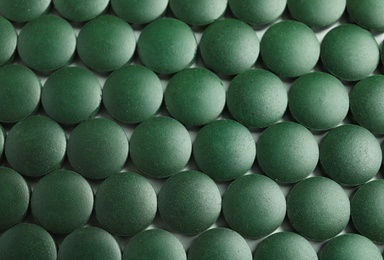 Photo of Spirulina tablets on table, top view. Healthy lifestyle