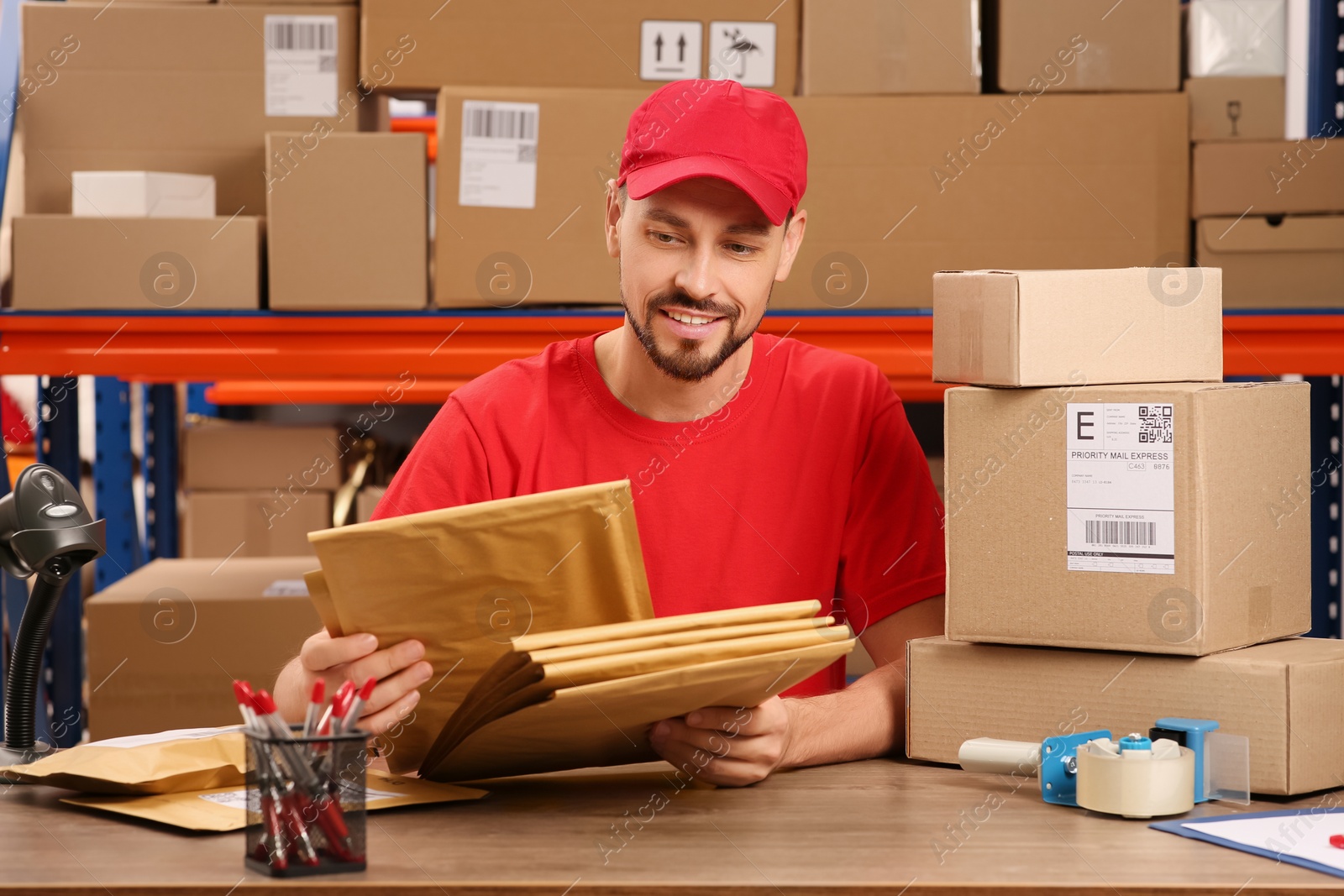 Photo of Post office worker with adhesive paper bags at counter indoors