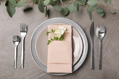 Photo of Festive table setting with plates, cutlery and napkin on grey background, flat lay