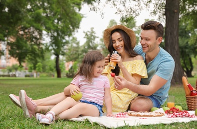 Photo of Happy family having picnic in park on summer day