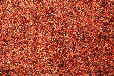 Photo of Chili pepper flakes as background, closeup