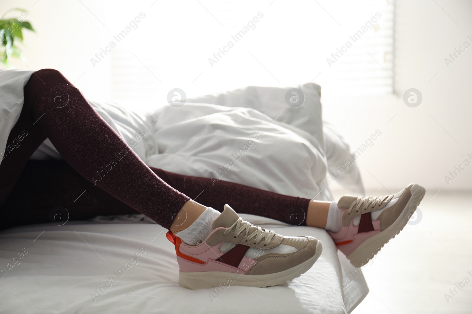 Photo of Lazy young woman sleeping on bed instead of morning training, closeup