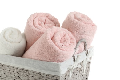 Photo of Rolled soft towels in basket on white background, closeup