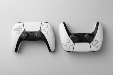 Photo of Wireless game controllers on light grey background, flat lay