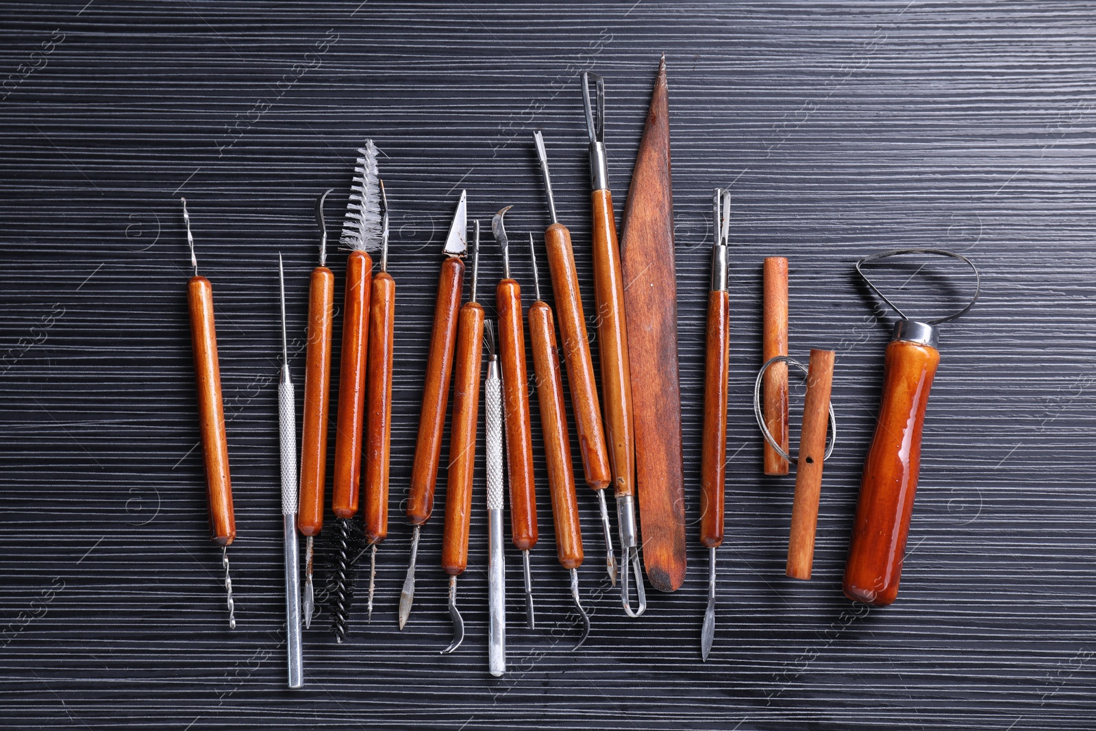 Photo of Set of clay crafting tools on black table, flat lay