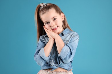 Cute girl in diadem on light blue background. Little princess