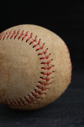 Worn baseball ball on black background, closeup