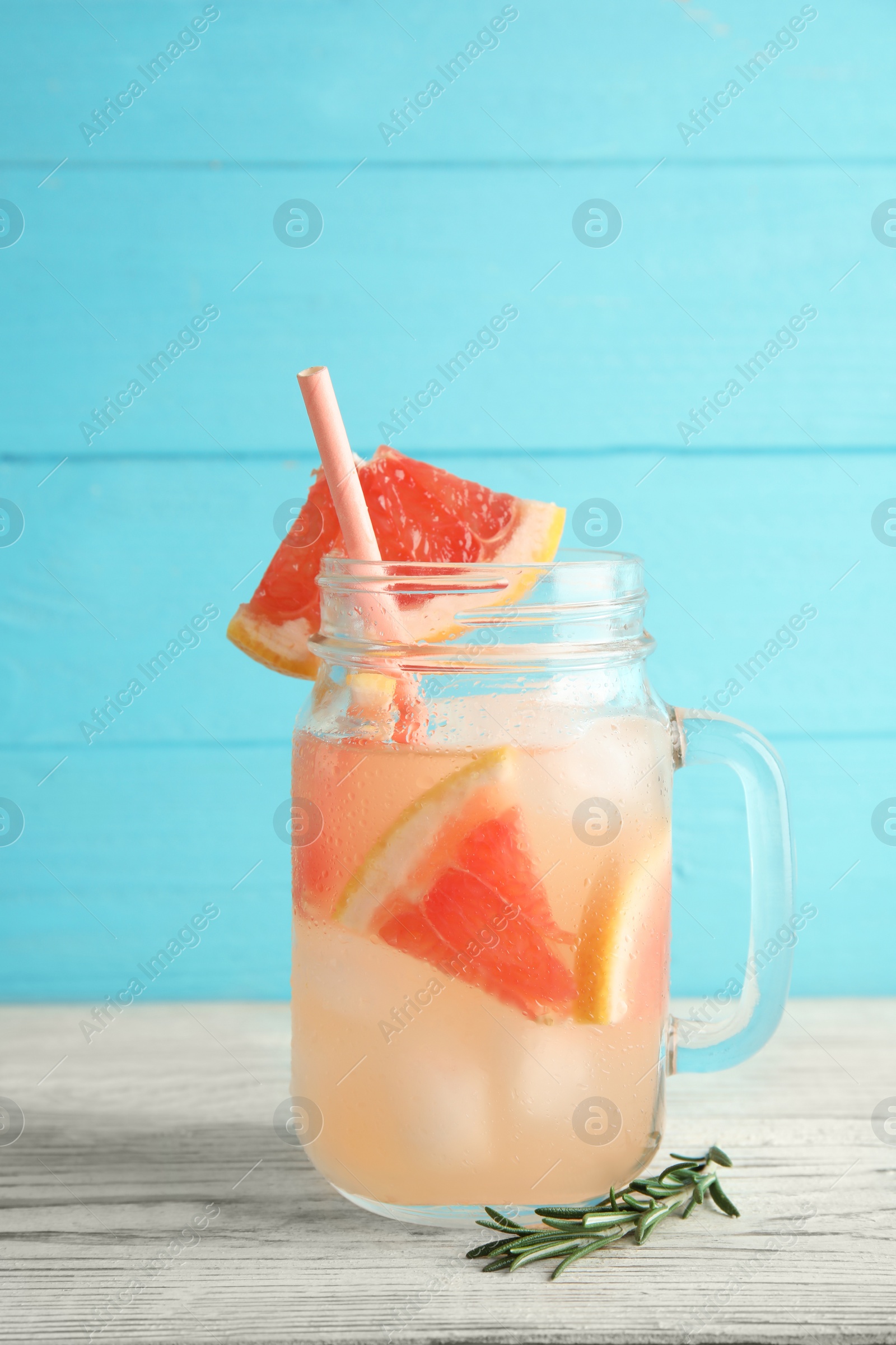 Photo of Mason jar with grapefruit cocktail on table. Space for text