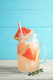 Mason jar with grapefruit cocktail on table. Space for text