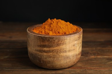 Aromatic saffron powder in bowl on wooden table