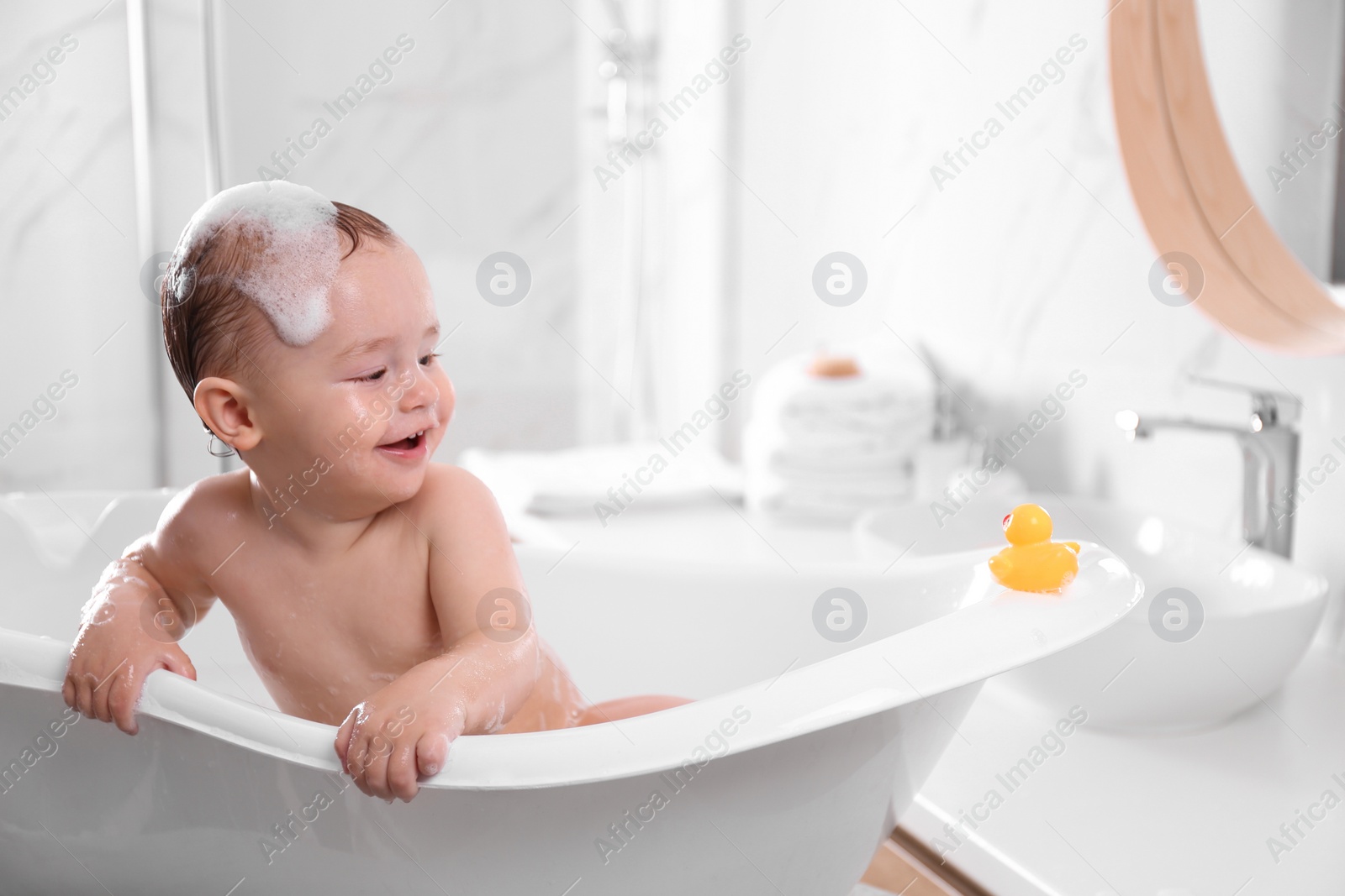 Photo of Cute little baby in bathtub at home