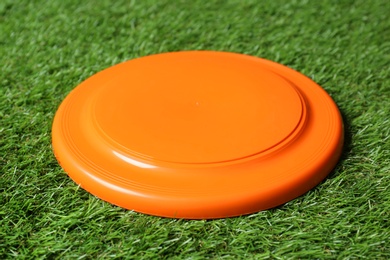 Photo of Orange plastic frisbee disk on green grass