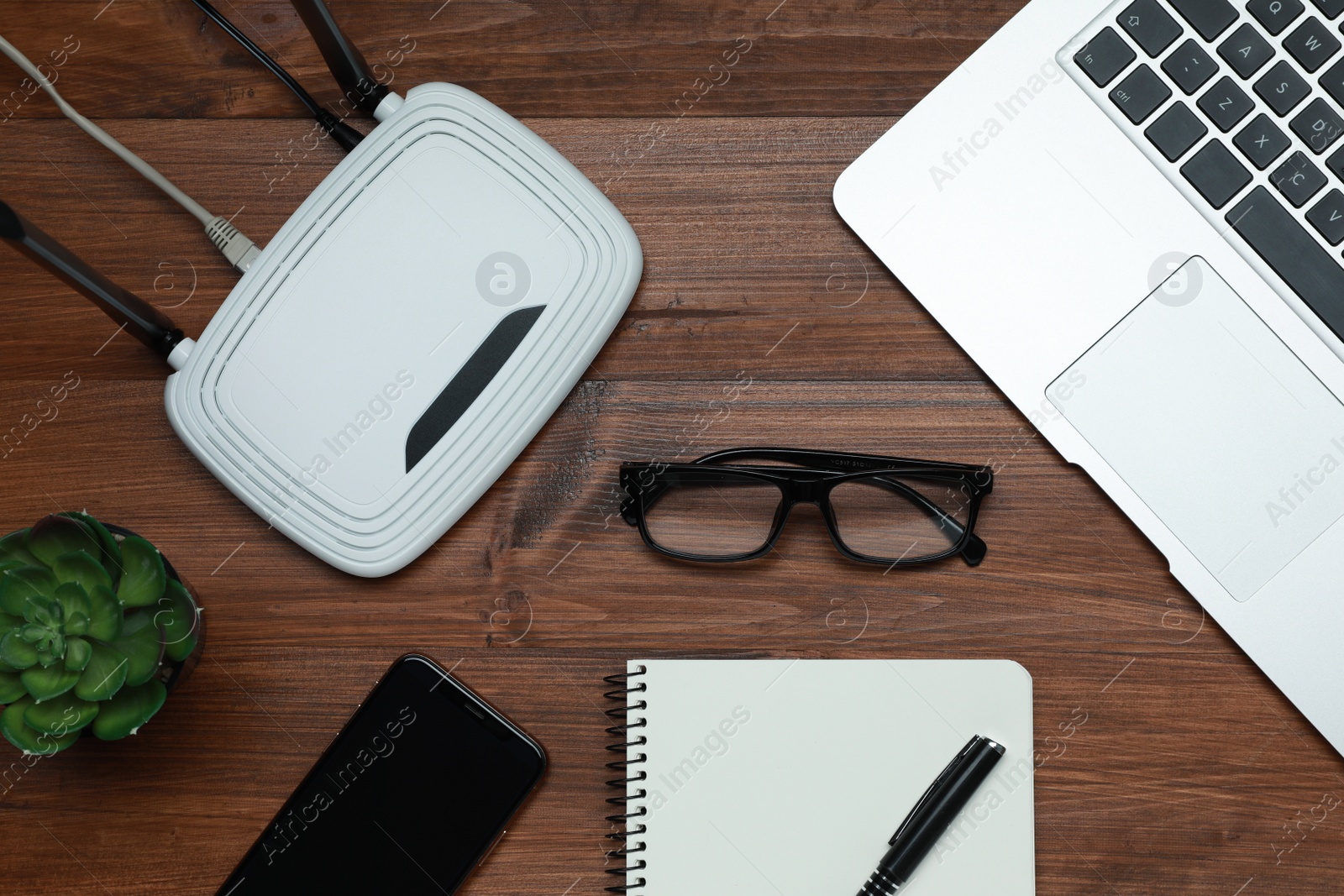 Photo of Composition with router, laptop and office stationery on wooden table, flat lay