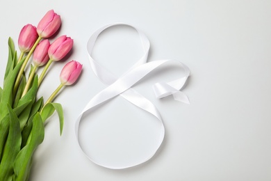 Photo of 8 March greeting card design with tulips and ribbon on light grey background, flat lay. International Women's day