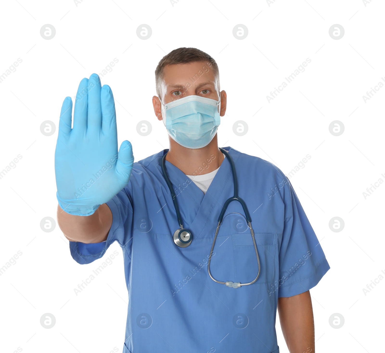 Photo of Doctor in protective mask showing stop gesture on white background. Prevent spreading of coronavirus