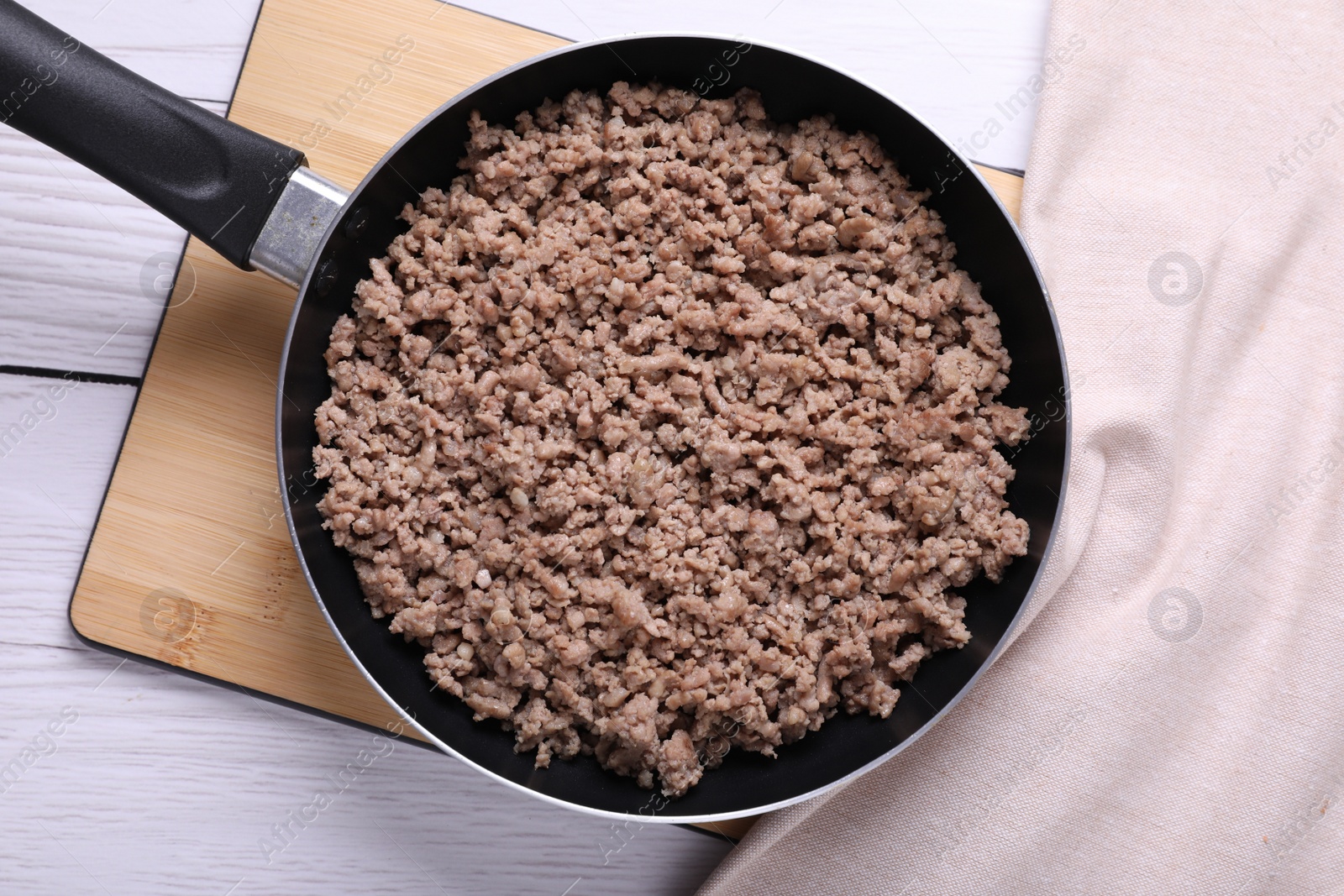 Photo of Fried minced meat in pan on white wooden table, top view